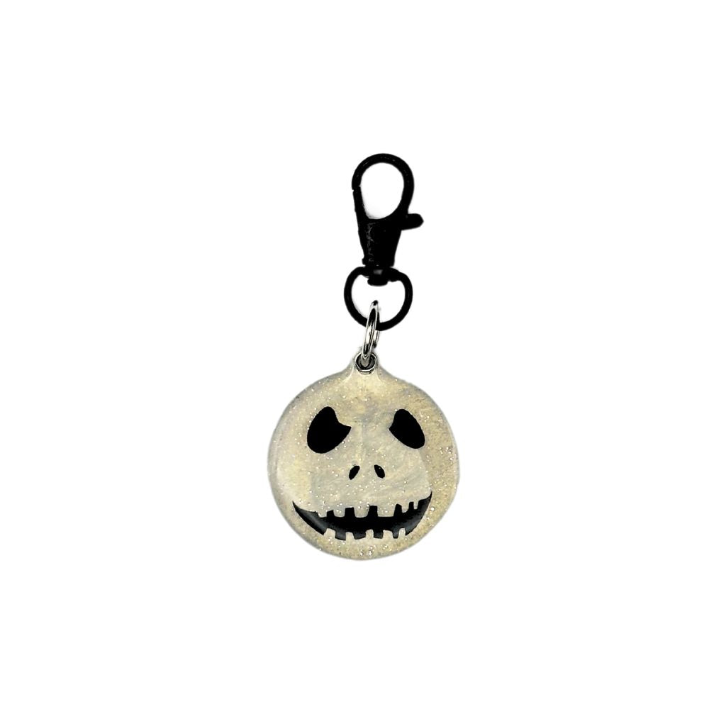 Skull-shaped pet ID tag made of resin with a customizable QR code and keychain clasp.