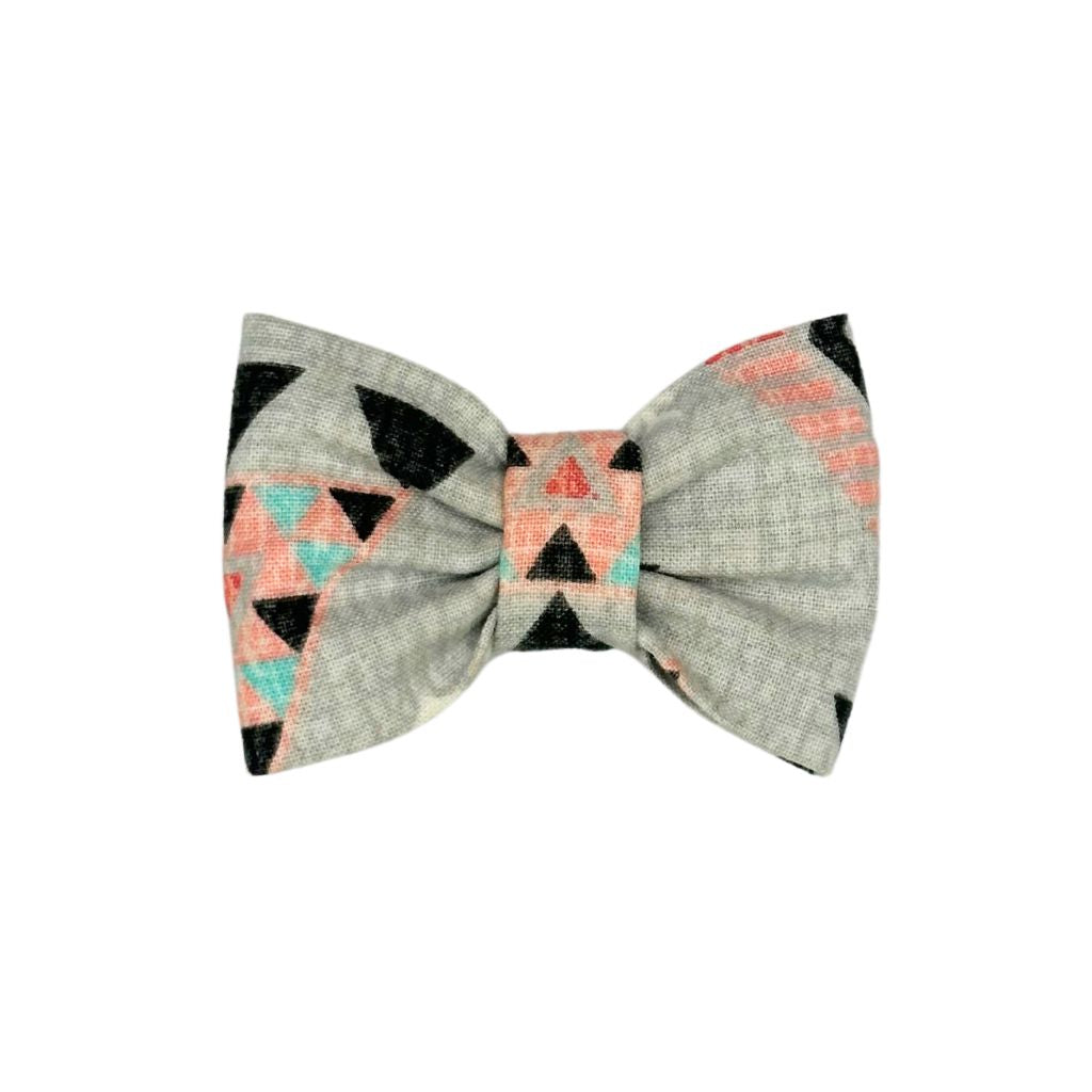Indigenous-inspired Cat Collar Bow featuring a geometric pattern with pastel pink, aqua, and black triangles on a soft gray background. Handcrafted by Beloved Lily's Pet Company.
