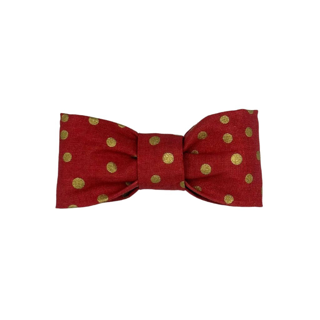 Red dog collar bow with gold polka dots, handcrafted pet accessory with elastic loops for easy attachment.
