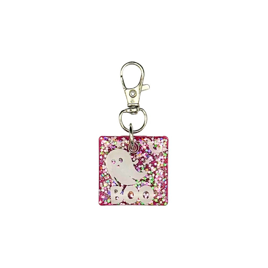 Square-shaped pet ID tag made of pink glitter resin with a ghost design and the word "BOO," featuring a customizable QR code and keychain clasp.