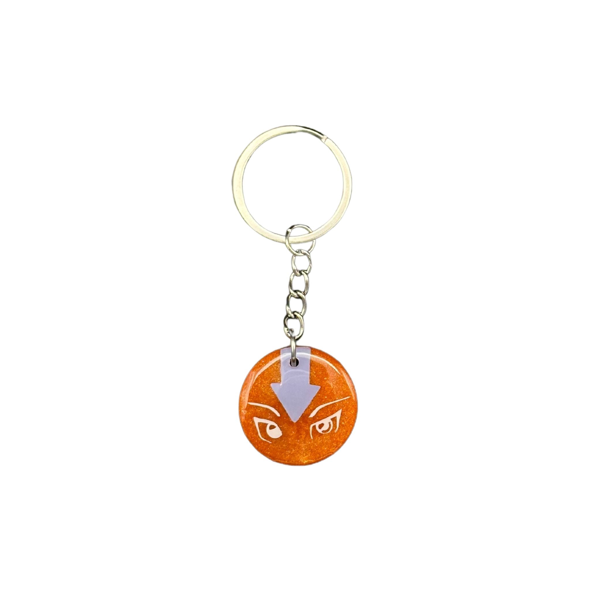 Front view of the "Playful Kitty" orange circular resin ID tag, showcasing the vibrant orange background with animated white cat eyes and a blue arrow pointing downward, protected by a clear resin layer.